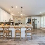 Four barn wooden bar chairs next to an open kitchen